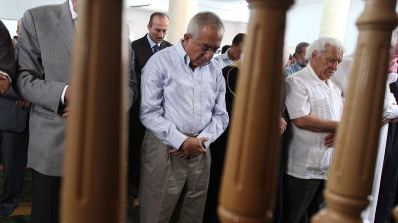 Palestinian prime minister Salam Fayyad, centre, takes part in Friday prayers in the West Bank village of Al Mughayer, near Ramallah, Friday, June 10, 2011. (AP Photo/Majdi Mohammed)