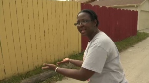 Home daycare operator Jackie Mighty gestures to where she saw a man lurking outside her backyard asking to be let in so he could "keep the children company."