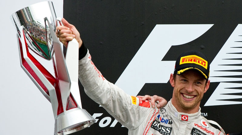 McLaren Mercedes driver Jenson Button, of Britain holds up the throphy during victory ceremonies after winning the Canadian Grand Prix, Sunday, June 12, 2011 in Montreal. (Paul Chiasson / THE CANADIAN PRESS)