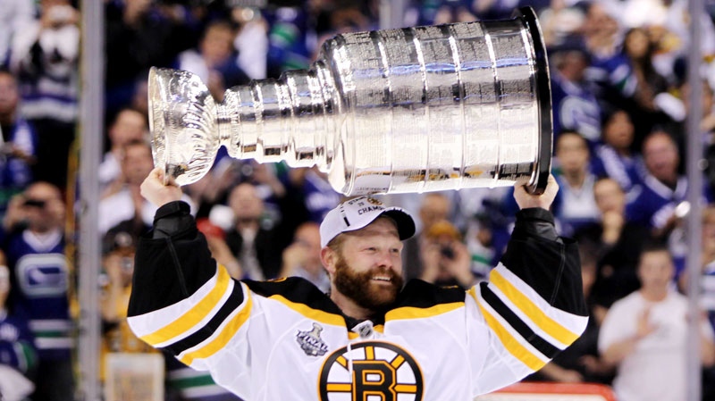 Boston Bruins goalie Tim Thomas hoists the cup following his teams 4-0 win over the Vancouver Canucks in game 7 of NHL Stanley Cup Final hockey at Rogers Arena in Vancouver, Wednesday, June 15, 2011. (Jonathan Hayward / THE CANADIAN PRESS)