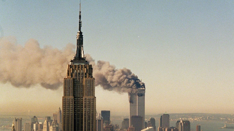 FILE- This Sept. 11, 2001 file photo shows the twin towers of the World Trade Center burning behind the Empire State Building in New York. The book world plans a low-key remembrance of the upcoming 10th anniversary of the Sept. 11 terrorist attacks.