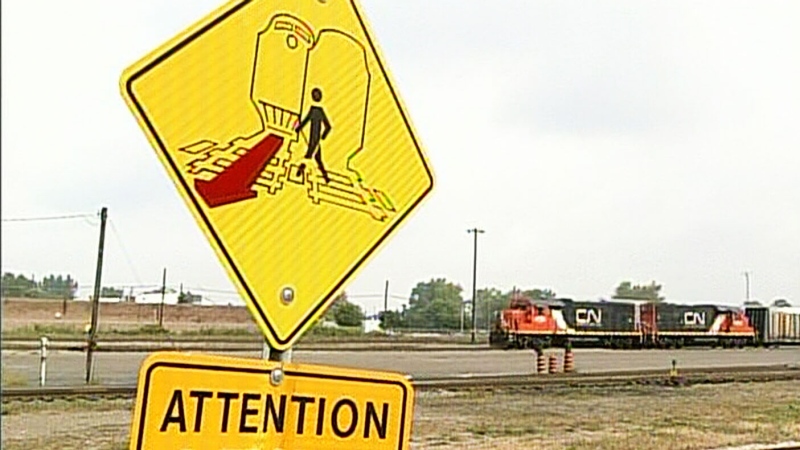 A sign warns pedestrians at a train crossing in London, Ont. on Friday, Oct. 4, 2013.