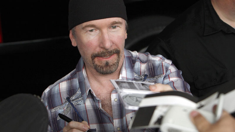 Guitarist of the Irish rock band U2, The Edge, signs autographs to fans in Mexico City, Wednesday, May 11, 2011. U2 will perform in concert in Mexico City on May 11, 14 and 15. (AP Photo/Marco Ugarte)