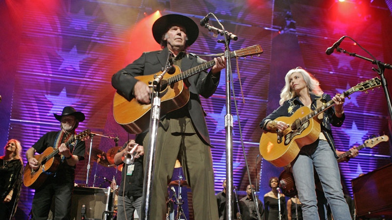 Willie Nelson, left with guitar, Neil Young, center, and Emmylou Harris perform at the 20th anniversary Farm Aid concert, Sunday, Sept. 18, 2005, in Tinley Park, Ill. The day-long concert is the culmination of a week of events to benefit family farmers. (AP Photo/Brian Kersey)