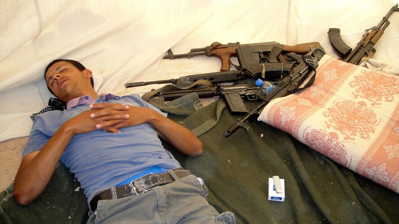 A rebel fighter takes a rest before clashes with pro-Moammar Gadhafi forces at the front line of Dafniya in Misrata, Libya, Saturday, June 18, 2011. (AP)