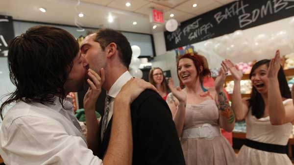 Lush Cosmetic employees Daniel Gervais, left, and David Casavant take part in a Kiss and Tell event in support of marriage equality as Amanda Halderman, second from right, and Perry Sun cheer them on, Saturday, June 18, 2011 in New York. The State Senate left the Capitol on Friday without tackling same-sex marriage and other key issues, but Gov. Andrew M. Cuomo insisted lawmakers are on track to take action before the end of the legislative session slated for Monday. (THE ASSOCIATED PRESS / Mary Altaffer)