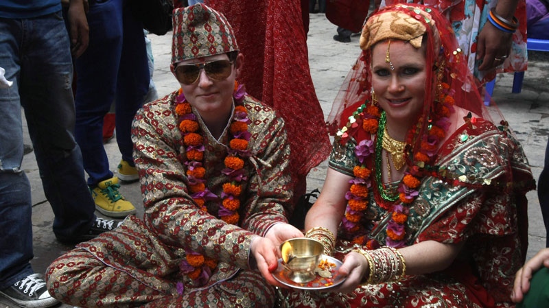 Courtney Mitchell, a college professor, left and Sarah Welton, a lawyer, perform a ritual during their wedding ceremony at a Hindu temple in Katmandu, Nepal, Monday, June 20, 2011. (AP Photo/Binod Joshi)