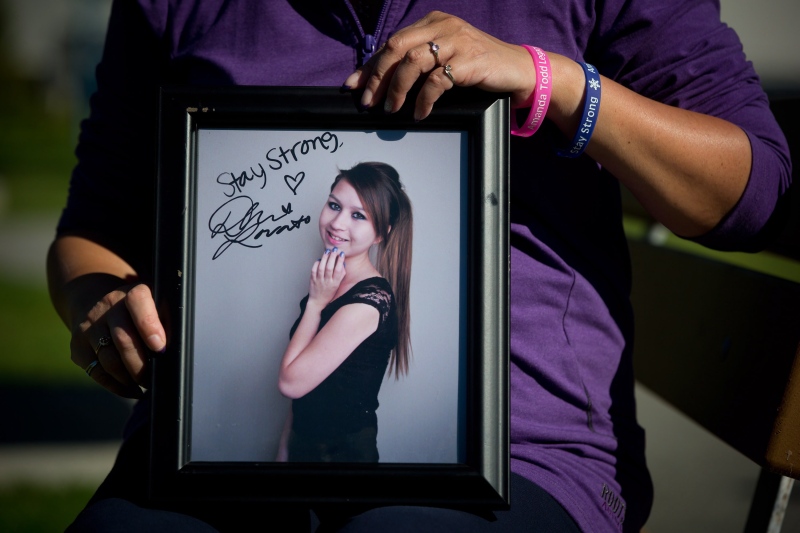Carol Todd holds a photograph of her late daughter Amanda Todd signed by U.S. singer Demi Lovato with the words 'Stay Strong' in Port Coquitlam, B.C., on Oct. 5, 2013. (Darryl Dyck / THE CANADIAN PRESS)