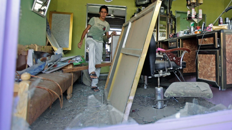 Ahmed Sadiq inspects his damaged barber shop in Baghdad, Iraq, Monday, June 20, 2011. (AP / Karim Kadim) 