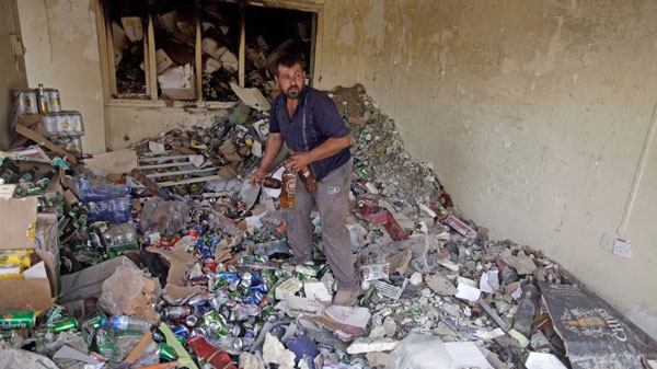 A liquor store owner inspects his destroyed shop after a bomb attack in Baghdad, Iraq, Tuesday, June 21, 2011. (AP / Karim Kadim)
