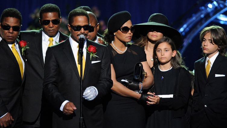 Michael Jackson's siblings, from left, Tito Jackson, Jermaine Jackson, Marlon Jackson, Randy Jackson, partially obscured, Janet Jackson, LaToya Jackson and children Paris and Prince Michael Jackson stand on the stage at the memorial service for music legend Michael Jackson at the Staples Center in Los Angeles on Tuesday, July 7, 2009. (AP Photo/Gabriel Bouys, pool) 