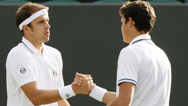 Luxembourg's Gilles Muller, left, and Canada's Milos Raonic shake hands after Raonic retired from the match at the All England Lawn Tennis Championships at Wimbledon, Wednesday, June 22, 2011. (AP Photo/Alastair Grant)
