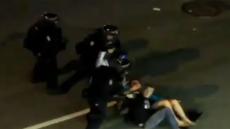 A new video posted on the website YouTube shows "kissing couple" Alexandra Thomas and Scott Jones being charged by a fast-moving line of riot police before falling to the ground. (YouTube)