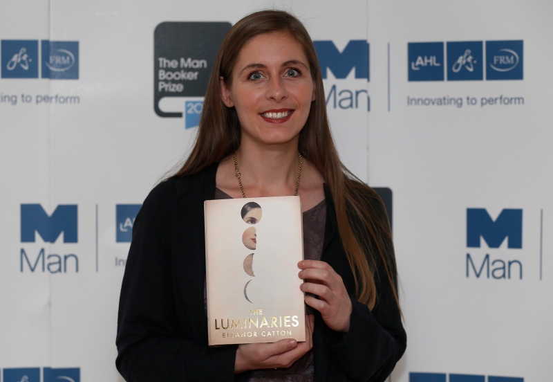 New Zealand author Eleanor Catton poses with her book 'The Luminaries' during a photocall for the shortlisted authors of the 2013 Man Booker Prize for Fiction at the Queen Elizabeth Hall in London on Sunday, Oct. 13, 2013. (AP Photo/Sang Tan)