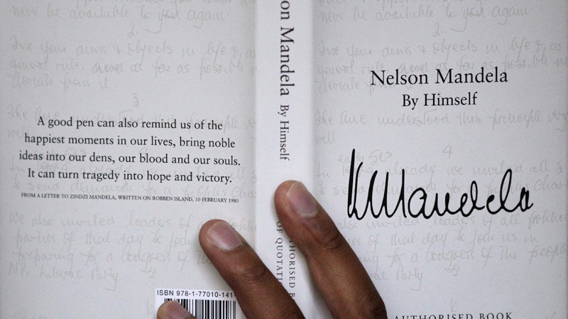 A copy of former South African president Nelson Mandela's newly released book, titled Nelson Mandela By Himself, is held up for a photograph in Johannesburg, South Africa, Monday, June 27, 2011. (AP Photo/Themba Hadebe)