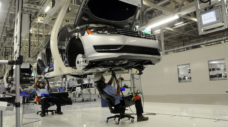 Workers inspect the undercarriage of a new Passat inside the new Volkswagen plant in Chattanooga, Tenn. on Tuesday, May 24, 2011. (AP Photo/Billy Weeks)