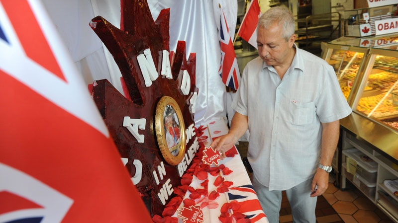 Claude Bonnet of Le Moulin de Provence bakery in the Byward Market prepares a window display in preparation for the Royal visit, Wednesday, June 29, 2011. THE CANADIAN PRESS/Sean Kilpatrick