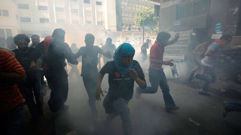 Egyptian protesters run to avoid tear gas during clashes with security forces, unseen at Tahrir Square in Cairo, Egypt Wednesday, June 29, 2011. (AP / Nasser Nasser)