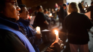 Residents attend a candlelight vigil at the West Hamilton Beach Volunteer Fire Department to commemorate the one-year anniversary of Superstorm Sandy, Monday, Oct. 28, 2013, in the Queens borough of New York. (AP Photo/John Minchillo)