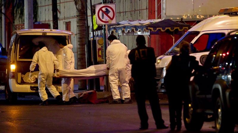 Forensic workers load a truck with bodies after gunmen stormed into a nightclub in Monterrey, Mexico, Friday July 8, 2011. (AP / Hans Maximo Musielik)