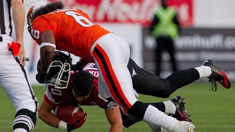 B.C. Lions' Stanley Franks, right, knocks the helmet off Calgary Stampeders' Johnny Forzani during the first half of a CFL football game in Vancouver, B.C., on Friday July 8, 2011. (THE CANADIAN PRESS/Darryl Dyck)