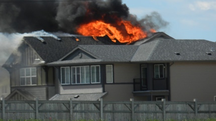 Flames billow out of roofs of a Southeast house