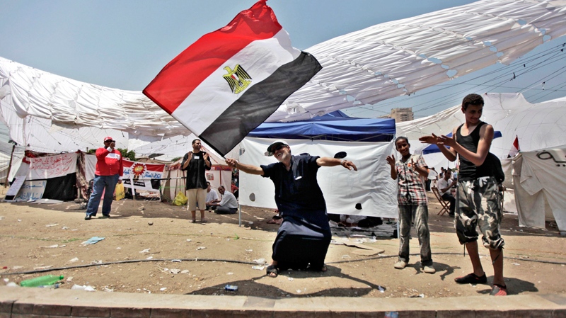 An Egyptian man dances with a national flag as he protests for a second day in Tahrir Square in Cairo, Egypt, Saturday, July 9, 2011.  (AP / Khalil Hamra)