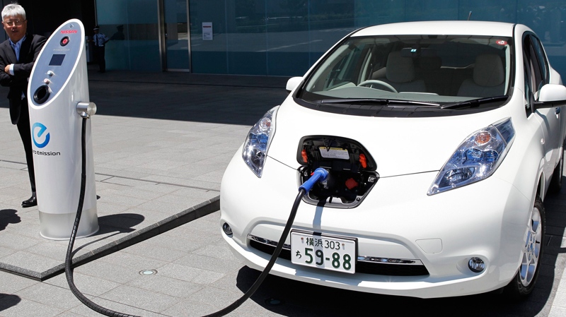 Nissan Motor Co. chief vehicle engineer Hidetoshi Kadota demonstrates a quick charge of a Nissan Leaf by a solar-assisted EV charging system at Nissan's global headquarters in Yokohama, Japan, Monday, July 11, 2011. (AP / Koji Sasahara)