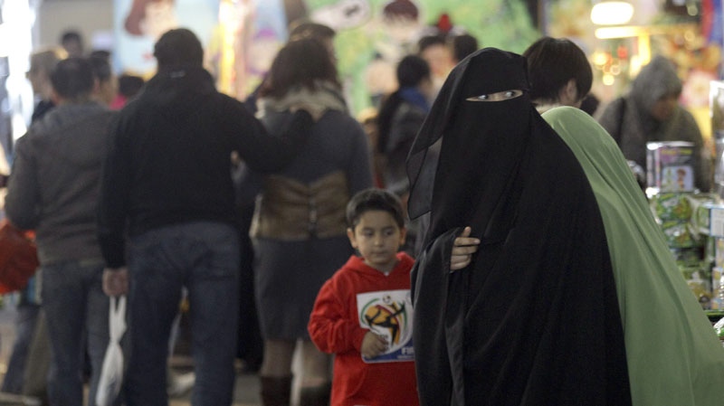 A Muslim woman wearing a burqa shops at a local market in Sydney Sunday, July 10, 2011. (AP Photo/Rob Griffith)