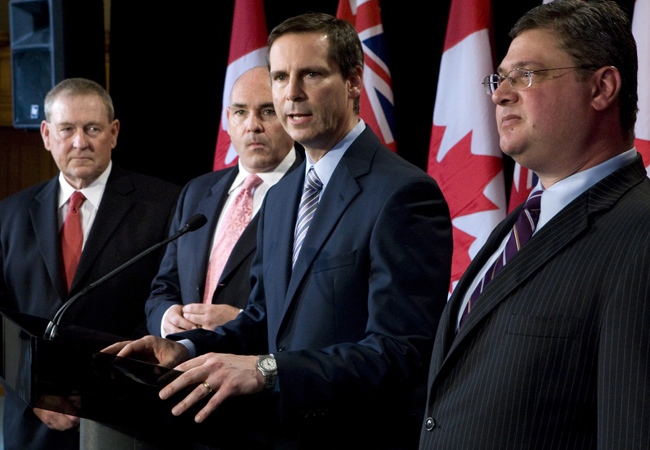 Ontario Premier Dalton McGuinty responds to a question as minister without a portfolio Gerry Phillips, Energy and Infrastructure Minister George Smitherman and Health Minister David Caplan (right) look on after the swearing in ceremony at Queen's Park in Toronto on Friday, June 20, 2008. (Adrian Wyld / THE CANADIAN PRESS)
