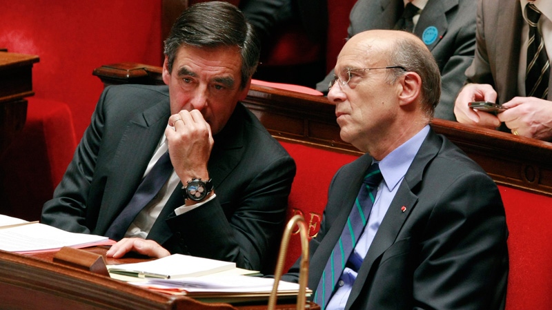 French Prime Minister Francois Fillon, left, speaks with France's Foreign Affair Minister Alain Juppe during a debate on the French intervention in Libya at the National Assembly in Paris, Tuesday, July 12, 2011. (AP / Jacques Brinon)