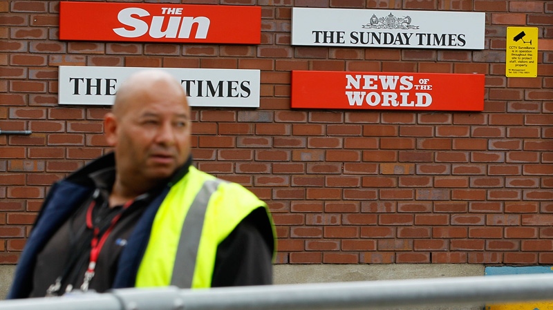 A security guard keeps watch at News International in Wapping, London, Thursday, July 14, 2011. (AP / Kirsty Wigglesworth)