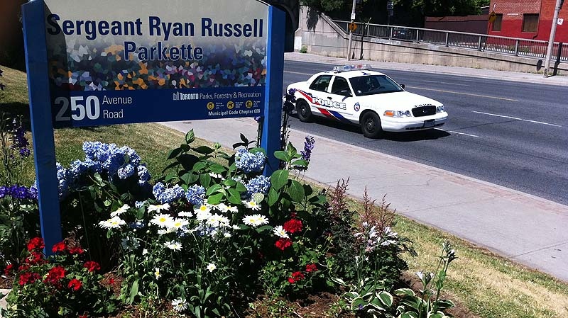 A new sign for Sergeant Ryan Russell Park stands in a flower bed following the renaming ceremony Friday July 15, 2011. (Tristan Philips / CTV News)