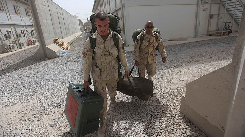 Canadians soldiers carry their baggage before leaving for home at Kandahar airbase in Afghanistan, Sunday, July 17, 2011. Canadian combat operations have ended and their troops will transition to a non-combat training role with up to 950 soldiers and support staff to train Afghan soldiers and police in areas of the north, west and Kabul.(AP Photo/Rafiq Maqbool)