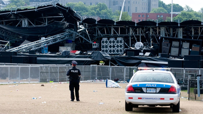 A police officer watches over the Ottawa Bluesfest's collapsed main stage  in Ottawa, Monday July 18, 2011. (Adrian Wyld / THE CANADIAN PRESS)