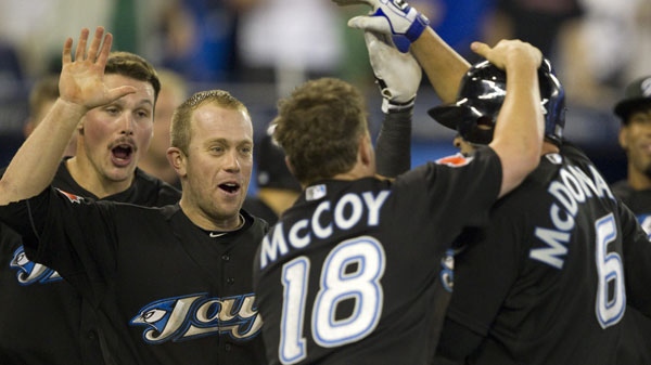 Toronto Blue Jays John McDonald (right) is congratulated by teammates Travis Snider (left), Aaron Hill (centre) and Mike McCoy after his game winning sac-fly in 14th inning AL action against the Seattle Mariners in Toronto on Tuesday July 19, 2011. THE CANADIAN PRESS/Frank Gunn