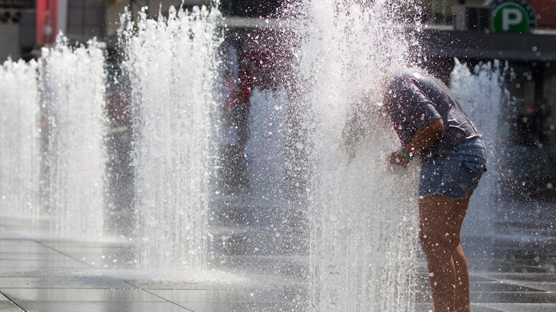 Cassidy Bates stands in a fountain as a heat wave hits Toronto Thursday, July 21, 2011.  (Darren Calabrese / THE CANADIAN PRESS)
