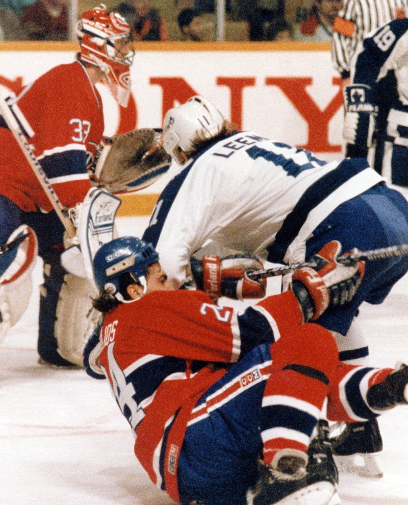 Toronto Maple Leafs' Gary Leeman upends Montreal Canadiens' Chris Chelios while goaltender Patrick Roy looks on during first period NHL action in Toronto on Jan. 27, 1990. (Bill Becker / THE CANADIAN PRESS)