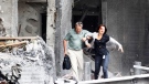 An injured woman is assisted from a damaged building in Oslo, after an explosion rocked the capital, Friday July 22, 2011. (AP / Scanpix, Morten Holm) 
