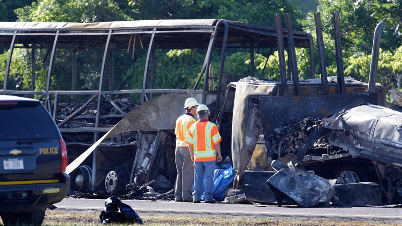 Workers evaluate the scene where a tractor-trailer crashed into a tour bus carrying about 50 people on the New York State Thruway in Waterloo, N.Y., Friday, July 22, 2011. (AP / David Duprey)