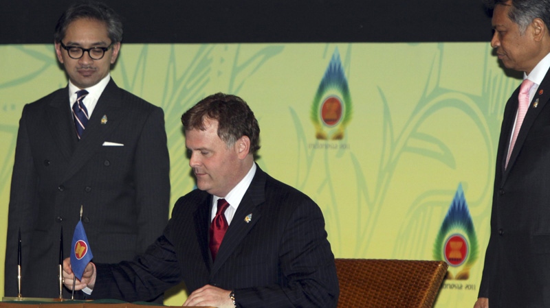 Indonesian Foreign Minister Marty Natalegawa, left, ASEAN Secretary General Surin Pitsuwan, right, and Canadian Foreign Minister John Baird, centre, attend a signing ceremony at the 44th ASEAN Ministerial meeting in Nusa Dua, Bali, Indonesia, Saturday, July 23, 2011. (AP Photo/Firdia Lisnawati)