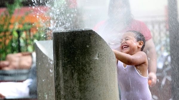 A child plays in a sprinkler, Saturday, July 23, 2011, in New York. (AP / Mary Altaffer)