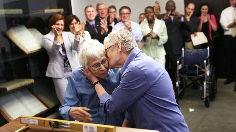 Phyllis Siegel, 77, right, kisses her wife Connie Kopelov, 85, after exchanging vows at the Manhattan City Clerk's office with New York City Council Speaker Christine C. Quinn in attendance, back left, on the first day New York State's Marriage Equality Act goes into effect, on Sunday, July 24, 2011. (AP / Michael Appleton)