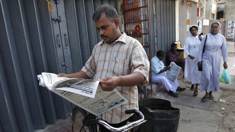 A Sri Lankan ethnic Tamil man reads a copy of newspaper in Jaffna, Sri Lanka, Sunday, July 24, 2011. (AP Photo/ Eranga Jayawardena)