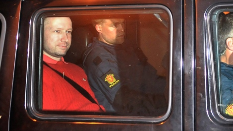 Norway's twin terror attacks suspect Anders Behring Breivik, left in red, sits in an armored police vehicle after leaving the courthouse following a hearing in Oslo Monday July 25, 2011. (Aftenposten / Jon-Are Berg-Jacobsen)