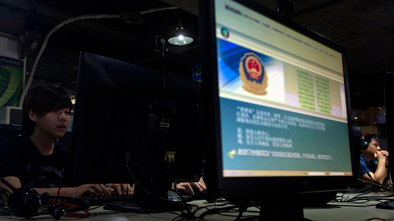 In this Monday, Aug. 19, 2013 file photo, computer users sit near a display with a message from the Chinese police on the proper use of the internet at an internet cafe in Beijing, China. (AP / Ng Han Guan)