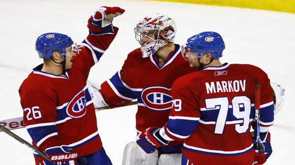 Montreal Canadiens goalie Carey Price is congratulated by teammates Josh Gorges, left, and Andrei Markov, from Russia, after shutting out the Vancouver Canucks 2-0 during NHL hockey action Tuesday, November 9, 2010 in Montreal. THE CANADIAN PRESS/Paul Chiasson