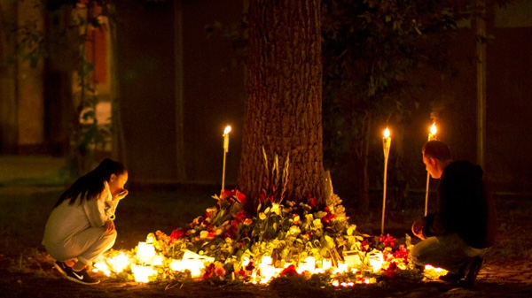 Candles burn as people look at tributes outside the Oslo Cathedral in Oslo, in memory of the victims of Friday's bomb attack and shooting rampage, in the early hours of Tuesday, July 26, 2011. (AP / Matt Dunham) 