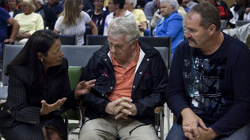 Senator Pierrette Ringuette, along with Berend Tepper and Jan Tepper, left to right, father and brother of potato farmer Henk Tepper, attend a public information session in Drummond, N.B. on Tuesday, July 26, 2011. (THE CANADIAN PRESS/Andrew Vaughan)
