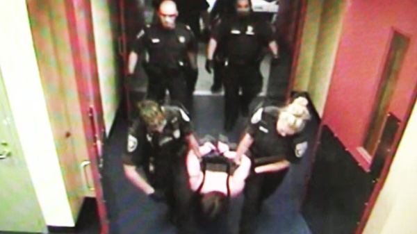Ottawa police hold Roxanne Carr in this image taken from a 2008 video. A cellblock video has been released that captures the arrest of a woman who claims Ottawa police injured and strip-searched her before leaving her naked in a cell without medical attention.